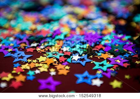 small multi-colored stars on a red background