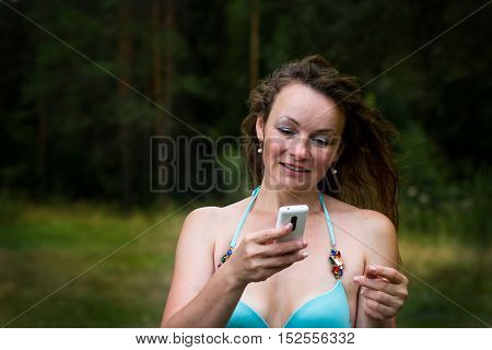 Girl In Bathing Suit In The Forest And Cell Phone