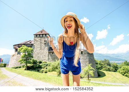 Vaduz, Liechtenstein - July 01, 2016: Young female tourist visits Vaduz castle in the capital of Liechtenstein. This castle is the palace and official residence of the Prince of Liechtenstein