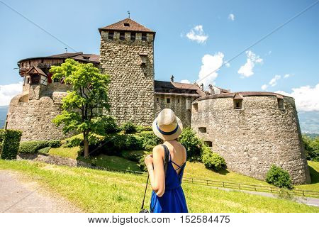 Vaduz, Liechtenstein - July 01, 2016: Young female tourist visits Vaduz castle in the capital of Liechtenstein. This castle is the palace and official residence of the Prince of Liechtenstein