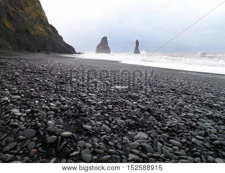 Reynisdrangur sea stacks and black sand beach in a windy day, Vik of South Iceland