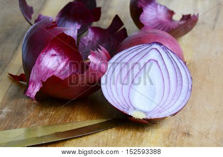 close up from peeled red onions on wooden board