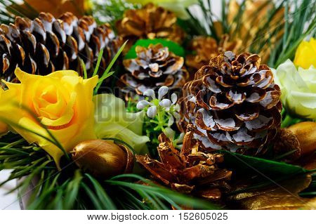 Christmas decoration with golden fir cones and silk roses. Christmas party background selective focus