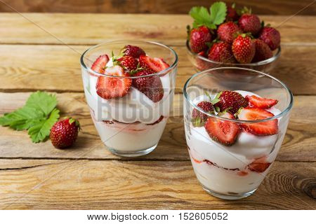 Summer layered cream cheese dessert and strawberry in glass bowl . Whipped cream with fresh strawberry.