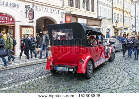 PRAGUE, OCTOBER 15: Old historic red car Praga on Mostovska street on October 15, 2016 in Prague, Czech Republic. Old cars are in Prague for tourists on tours of the city.