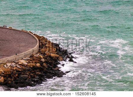 Shore side road with rocky coast and green water