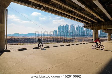 Cyclists under bridge by the Hangang river in Seoul