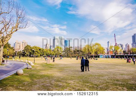 SHANGHAI - MARCH 15: Zhongshan park with Chinese people playing and walking on a sunny day on March 15 2016 in Shanghai.