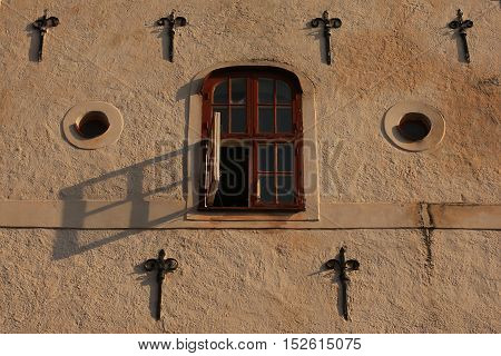 Shadow of an open window on an ancient house