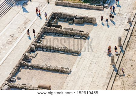 ZADAR CROATIA - SEPTEMBER 14: Birds eye view of tourists walking amongst the famous downtown ruins in the town center of Zadar on a hot sunny day on September 14th 2016 in Zadar