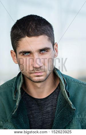Portrait of a man with pale blue eyes. Men's beauty. Street fashion. Eyes like a Husky.