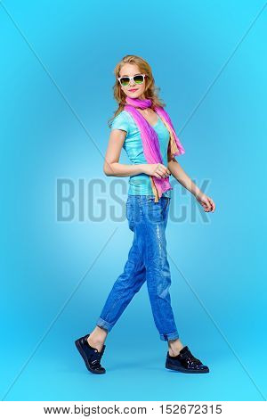 Full length portrait of a pretty young woman in summer clothes and sunglasses. 