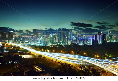 Abstract and car lighttrail background city skyline downtown background and highway interchanged nigh view .