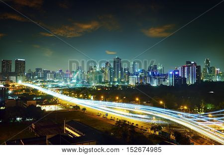 Abstract and car lighttrail background city skyline downtown background and highway interchanged nigh view .