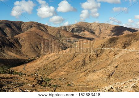 Beautiful volcanic mountains and the road on a mountain slope. Road from la Pared to Betancuria . Fuerteventura. Canary Islands