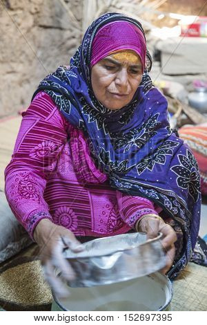 Omani Lady Using A Sieve