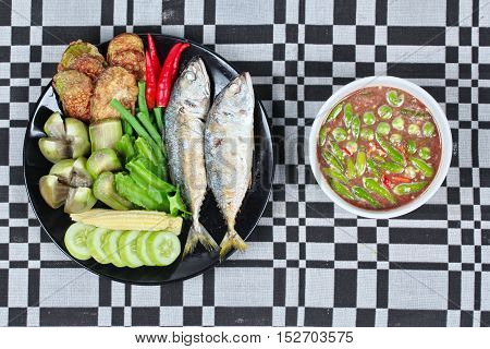 Thai local popular food as spicy shrimp paste dip (Nam Prik Kapi in Thai) iserved with side dish as deep fired mackarels,boiled long-eggplant,lentils,winged bean ,red hot chili pepper and cucumber.