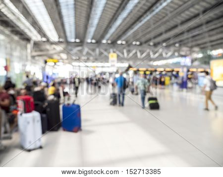 Blur background of airport hall with many suitcase and people