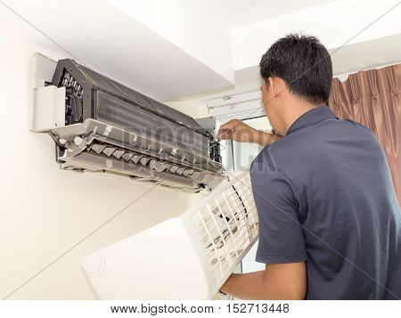 Single electrician man clean fix and maintain air conditioning in the house