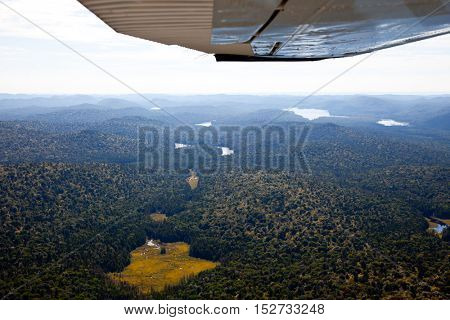 Adirondack forests, lakes, creeks and mountains aerial terrain view down from light aircraft