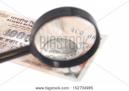 Indian Currency Rupee Note with magnifying glass isolated on white background