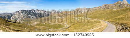 Panorama of the mountains in the national park of Montenegro and the narrow winding road leading up the mountain slope