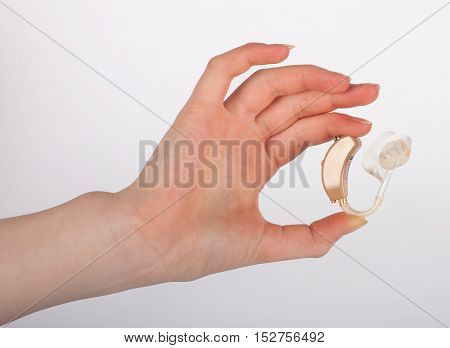 Hand showing a hearing aid with ear mould