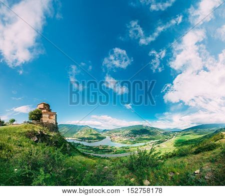 Mtskheta, Georgia. The Ancient Georgian Orthodox Church Of Holly Cross, Jvari Monastery With Remains Of Stone Wall, cenic Blue Cloudy Sky Background. World Heritage. Panorama
