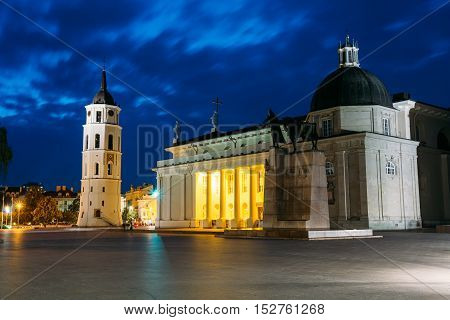 Vilnius, Lithuania. Night Or Evening View Of Cathedral Basilica Of St. Stanislaus And St. Vladislav With The Bell Tower, Blue Cloudy Sky Background. Catholic Cathedral At The Cathedral Square. Travel