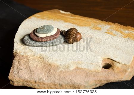 stacked stones with acorn on sandstone slab