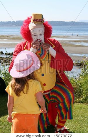 Clown faisant un ballon animal pour une petite fille