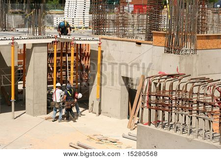 Quattro uomini al lavoro presso un cantiere di highrise.