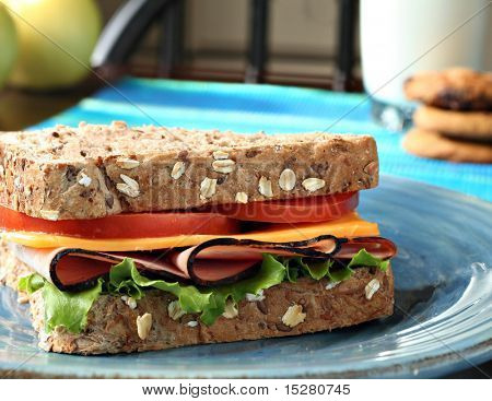 Schinken und Käse-Sandwich, Äpfel, Cookies und Milch.