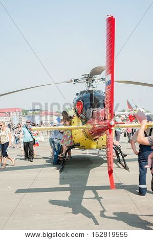 Tyumen, Russia - August 11, 2012: Air show On a visit at UTair in heliport Plehanovo. People explore Eurocopter AS-355NP Ecureuil 2