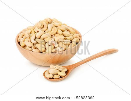 cashew nut in wooden bowl and spoon isolated on white