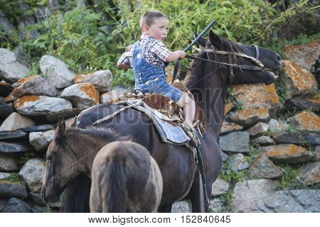 Ushguli Georgia - August 15 2016: Color image of a young boy riding a horse in the Caucasian village of Ushguli Georgia.