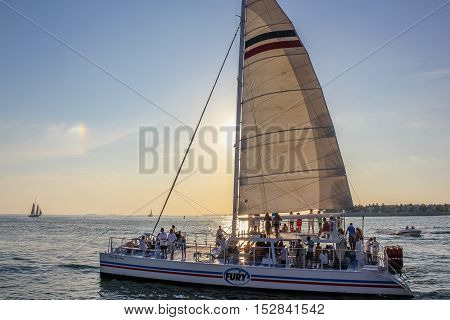 Key West, Florida, United States - April 13, 2012: people enjoy for the Sunset Celebration on a sailing ship left from the pier at Mallory Square in Key West.