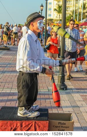 Key West, Florida, United States - April 13, 2012: street artist clown performs during the Sunset Celebration at Mallory Square. Show of street artists is one of most popular attractions of Key West.