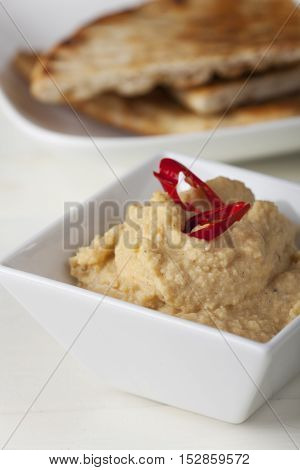 hummus spread with pita bread and chili