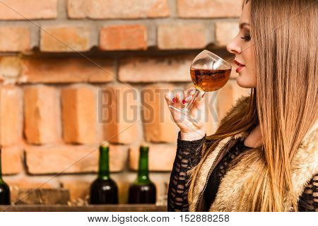 Elegant beauty lady long hair full make up wearing black dress tasting wine in rural cottage interior celler
