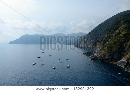 Boats in bay and cliff in Vernazza in Liguria Italy. One of five Cinque Terre cities (unesco world heritage)