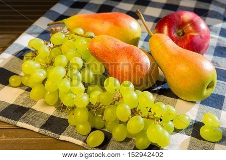 Grapes, pears and apples on a rustic wooden background