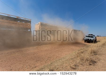 A cattle road train in the outback of Western Australia passes on dusty outback road.