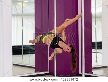 Beautiful pole dancer performing at the studio