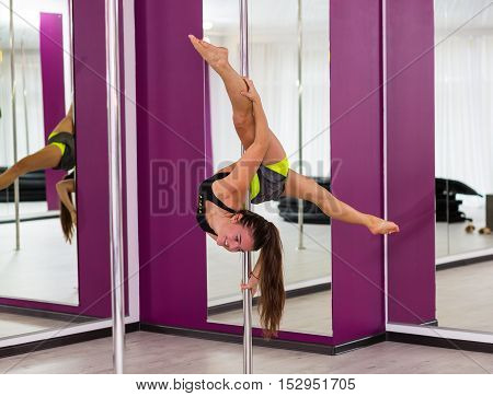 Beautiful pole dancer performing at the studio