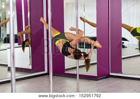 Beautiful pole dancer performing at the studio