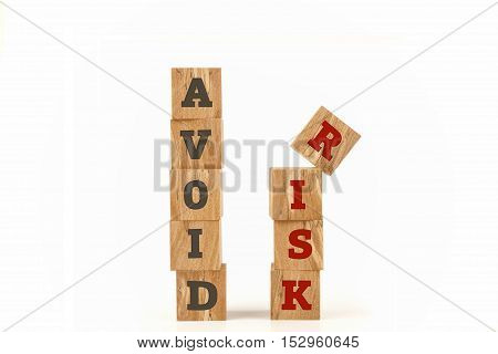 Avoid Risk word written on cube shape wooden surface isolated on white background.