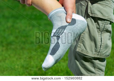 pain in the foot feet on the background of green grass