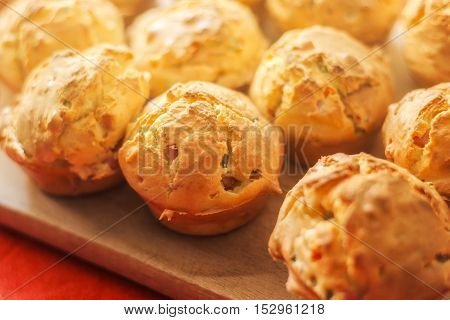 Tasty homemade salty cupcakes served on wooden plate selective focus