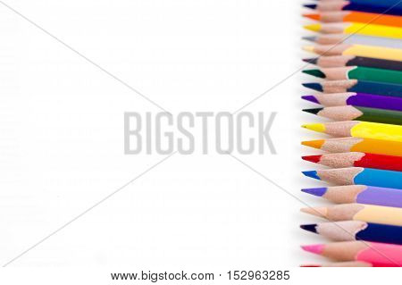 Colored pencils isolated on white background. Bright template with copyspace. Educational background.